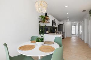 a dining room with a white table and green chairs at Heat of Siesta Village Walk to Beach w heated Pool in Siesta Key