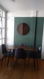 Una mesa de comedor con sillas y un espejo. en Frida my Loft, en Ciudad de México