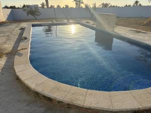 a large swimming pool with blue water at Dar El Amel in Mellita