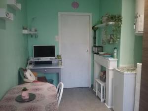 a room with a table and a desk with a computer at gîte La Valentina, climatisé in Cubjac-Auvézère-Val d'Ans