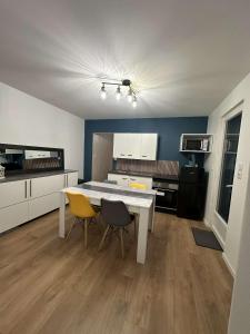 a kitchen with a white table and two chairs at 145 désirs in Samer