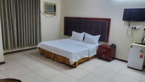 a bedroom with a large bed and a television at شقق لؤلؤه الفخامه in Al Qunfudhah