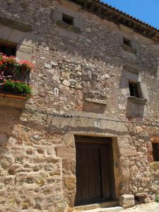 シグエンサにあるCasa de los Judi­osの窓に花と扉を持つ石造りの建物