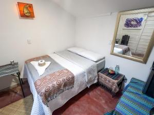 a bedroom with a bed and a mirror at Unicorn Reborn - Peaceful Rentals in San Marcos La Laguna