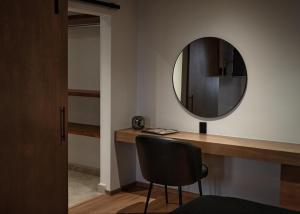 a mirror on a wall next to a desk with a chair at Casa Irene Hotel Boutique y Spa in San Luis Potosí