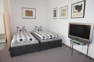 a bedroom with a bed with a television and pillows at Altstadtappartement Königswinter in Königswinter