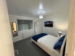 マンチェスターにある3 bedroom Luxurious property 5Mins from heaton parkのベッドとテレビのある寝室