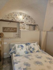 a bedroom with a bed with blue flowers on it at Nid Minéral - Suite voûtée de charme au cœur de Vallon Pont d'Arc in Vallon-Pont-dʼArc