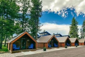 una fila di case di tronchi con sedie blu davanti di Blue Buffalo Resort a Island Park