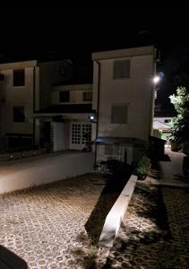 een gebouw 's nachts met een stenen pad ervoor bij Apartments Luigi in Umag