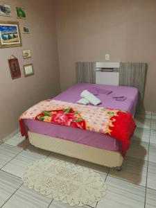 a bed with a purple comforter and flowers on it at Casa dei Nonni in Garibaldi