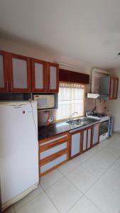 a kitchen with a refrigerator and a sink at Dpto Marina in Villa Cura Brochero