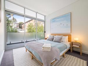 Un dormitorio con una cama y una ventana grande. en The Nancy Bondi, en Sídney