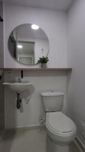 a bathroom with a toilet and a sink and a mirror at casa azul in Medellín