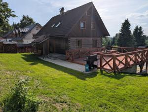 a house with a wooden fence and a yard at Chalet Kočí in Kořenov