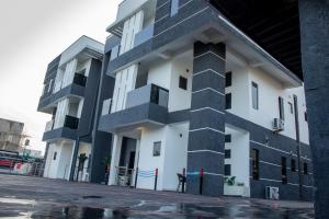 ibi's Apartment في Agege: مبنى أبيض وأسود مع الكثير من النوافذ