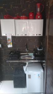 a kitchen with a stove and a sink in a wall at Casa Lilás Pipa A 4 min da praia e perto de tudo in Pipa