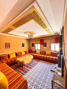 a living room with couches and a tv at Toubkal home stay in Imlil