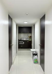 a kitchen with black cabinets and a white floor at Seganis casa hotel in Bogotá