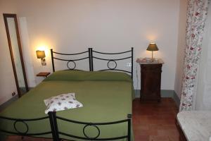 a bedroom with a green bed and a table at Villa San Leolino in Greve in Chianti