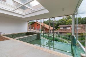 an indoor pool in a house with glass windows at Locar-in Canela Bellagio - Infraestrutura Completa in Canela