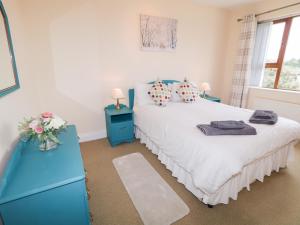 a bedroom with a bed and a blue dresser at Ard na Gréine in Kilrean +20 photos