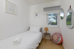 a bedroom with a bed and two windows at Pebble in Carbis Bay