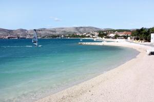 eine Person auf einem Segelboot im Wasser an einem Strand in der Unterkunft Apartment Trogir 15011c in Trogir