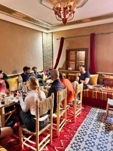 a group of people sitting at tables in a restaurant at Toubkal home stay in Imlil