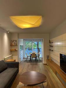 a living room with a table and a yellow ceiling at Venus Luxury Apartment in Skopje