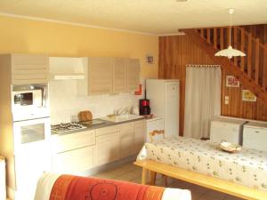 a kitchen with white cabinets and a white refrigerator at Maison rénovée avec jardin, SPA, vélos près des commerces - Animaux acceptés - FR-1-426-291 in Saint-Martin-de-Fraigneau