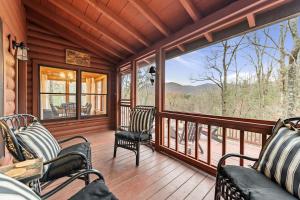 a screened in porch with chairs and a large window at Hidden Lake Lodge in Cherry Log