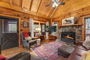 a living room with a fireplace in a log cabin at Hidden Lake Lodge in Cherry Log