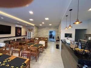 a dining room with tables and chairs in a restaurant at Torre Hotel in Jaguaquara
