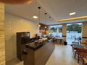 a kitchen with a counter and some tables and chairs at Torre Hotel in Jaguaquara