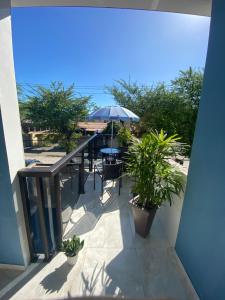 a balcony with a table and an umbrella at Sobrado para até 16 pessoas px ao centro in Porto De Galinhas