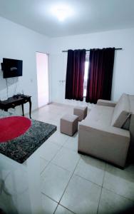 a living room with a couch and a television at Casa Conforto in Senador Canedo
