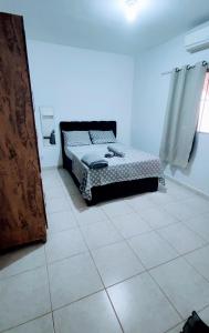 a bedroom with a bed and a tiled floor at Casa Conforto in Senador Canedo
