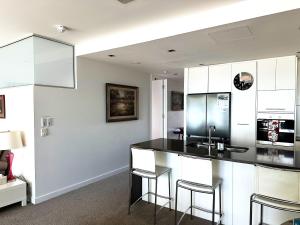 a kitchen with a black counter and stools at SEABREEZE at Victor Harbor in Victor Harbor