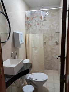 a bathroom with a shower and a toilet and a sink at Apartamento por temporada - Edifício Fernando Dias in Macapá