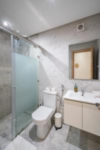 a bathroom with a toilet and a shower and a sink at LUXURY APARTMENT IN THE HEART OF MARRAKECH GUELIZ in Marrakech +108 photos