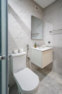 a white bathroom with a toilet and a sink at LUXURY APARTMENT IN THE HEART OF MARRAKECH GUELIZ in Marrakech