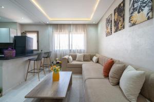 a living room with a couch and a table at LUXURY APARTMENT IN THE HEART OF MARRAKECH GUELIZ in Marrakech