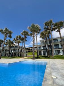 a large apartment building with palm trees and a swimming pool at Stunning Oceanview 2B Waterfront Apartement in Bijilo