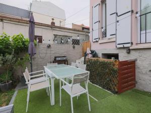 a patio with a table and chairs and an umbrella at House with garden 4BR 10P near Paris in Le Kremlin-Bicêtre