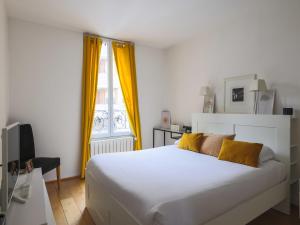 a bedroom with a large white bed with yellow curtains at House with garden 4BR 10P near Paris in Le Kremlin-Bicêtre