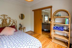 Un dormitorio con una cama y una habitación con un espejo. en Macs Beach Bungalow, en Macmasters Beach