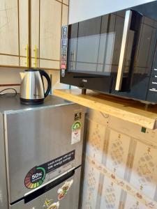 a microwave sitting on top of a refrigerator at Toly’s Spacious One Bedroom in Nairobi