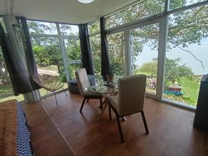 a living room with a table and chairs and windows at Abitare lodge Mezcala #2 in Isla de Mezcala +12 photos