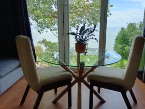 a glass table with two chairs and a glass window at Abitare lodge Mezcala #2 in Isla de Mezcala